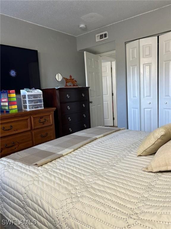 bedroom with a textured ceiling and a closet