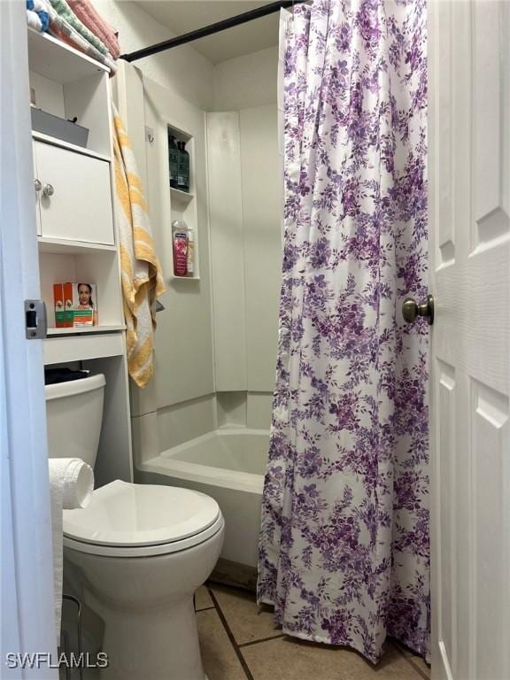 bathroom featuring tile patterned floors, toilet, and shower / bath combo with shower curtain