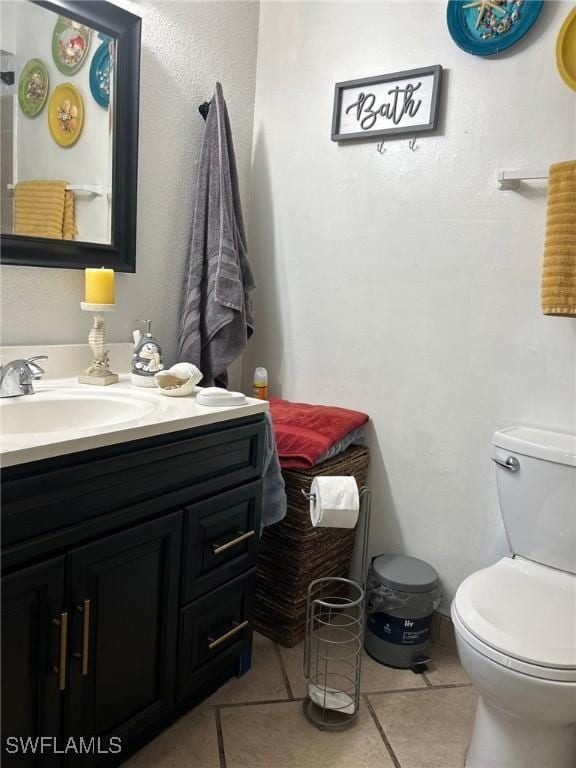 bathroom with tile patterned flooring, vanity, and toilet