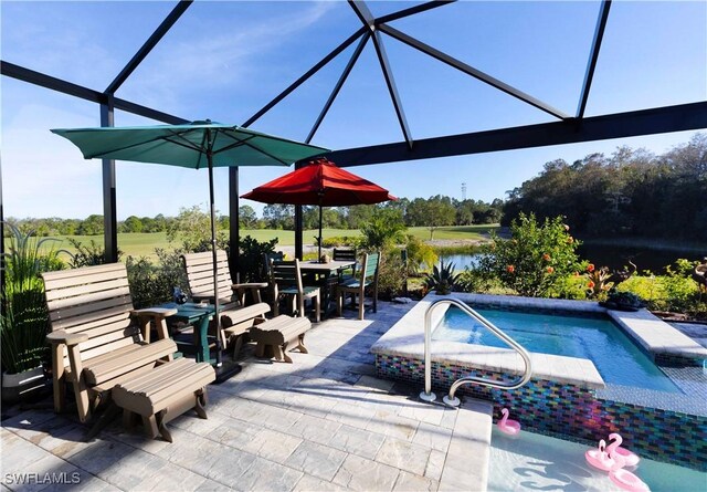 view of pool with glass enclosure, a water view, and a patio