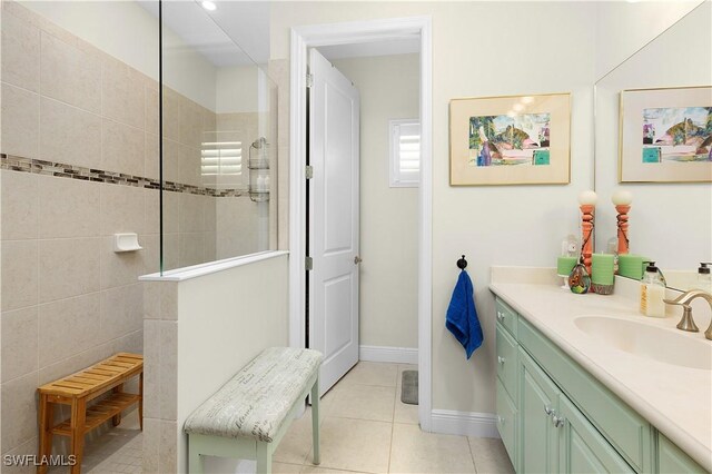 bathroom with tile patterned floors, vanity, and tiled shower