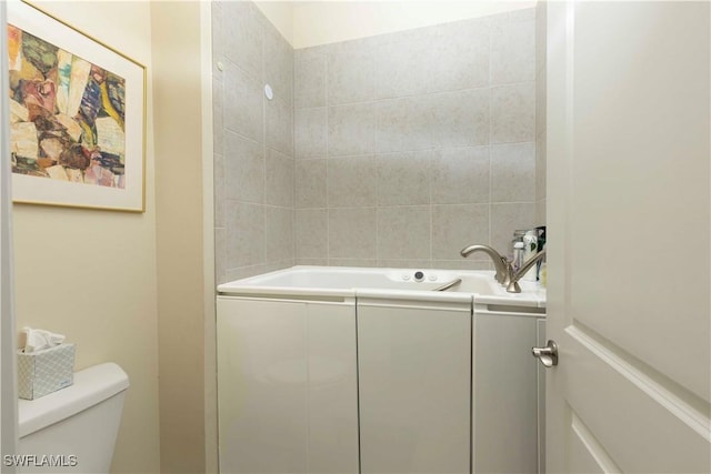 bathroom with a tub, sink, and toilet