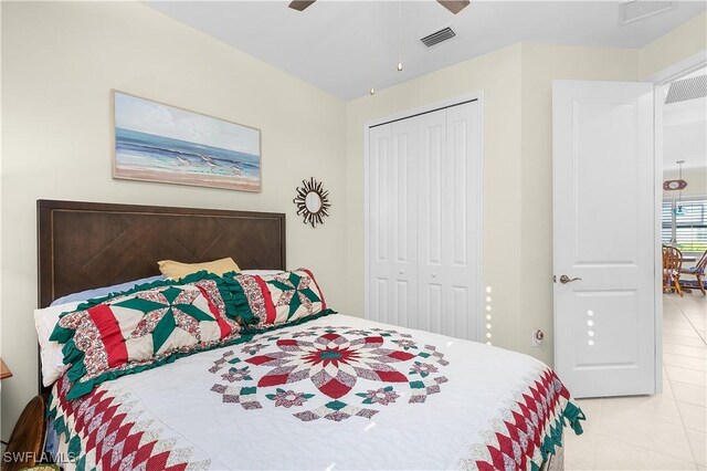 bedroom with light tile patterned flooring, a closet, and ceiling fan