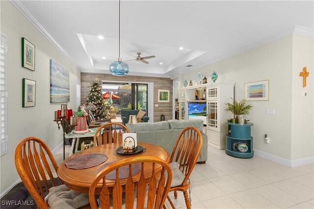 dining room featuring a skylight, ceiling fan, ornamental molding, a tray ceiling, and light tile patterned flooring