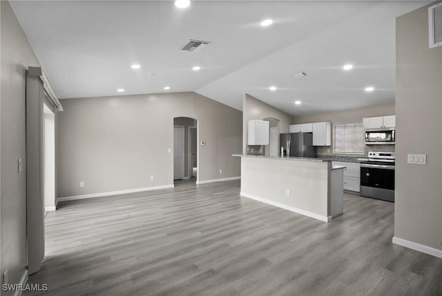 kitchen featuring hardwood / wood-style flooring, white cabinetry, lofted ceiling, and stainless steel appliances