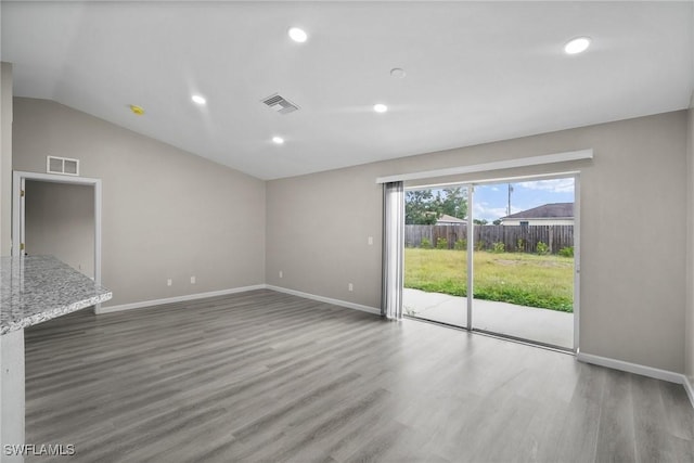 unfurnished living room with vaulted ceiling and dark hardwood / wood-style floors