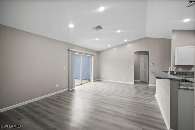 unfurnished living room featuring dark hardwood / wood-style floors and vaulted ceiling