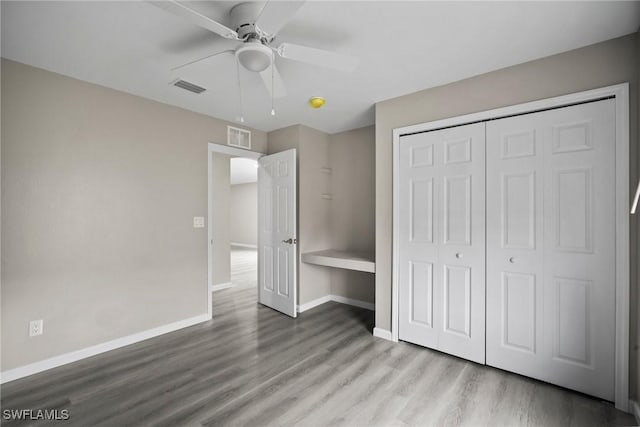 unfurnished bedroom with a closet, light hardwood / wood-style floors, and ceiling fan