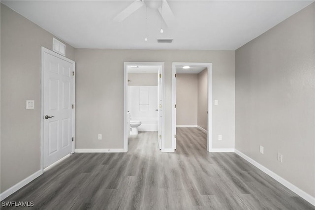 unfurnished bedroom featuring connected bathroom, ceiling fan, and wood-type flooring