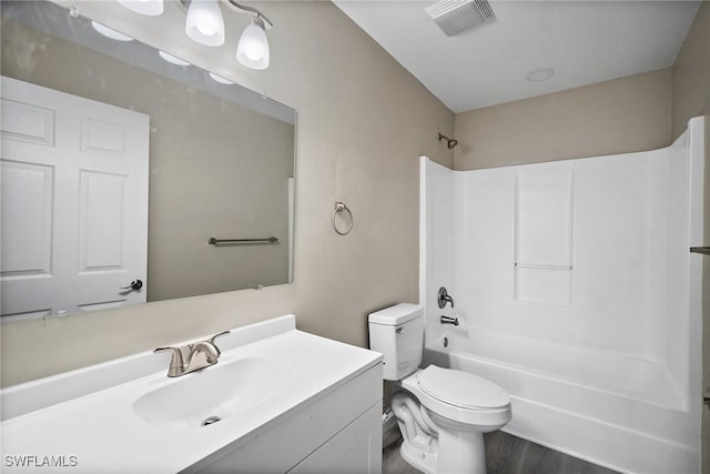 full bathroom with vanity, hardwood / wood-style flooring, toilet, and shower / washtub combination