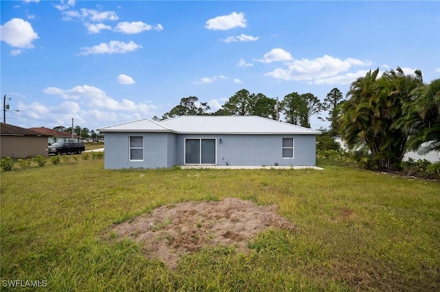 rear view of house featuring a yard