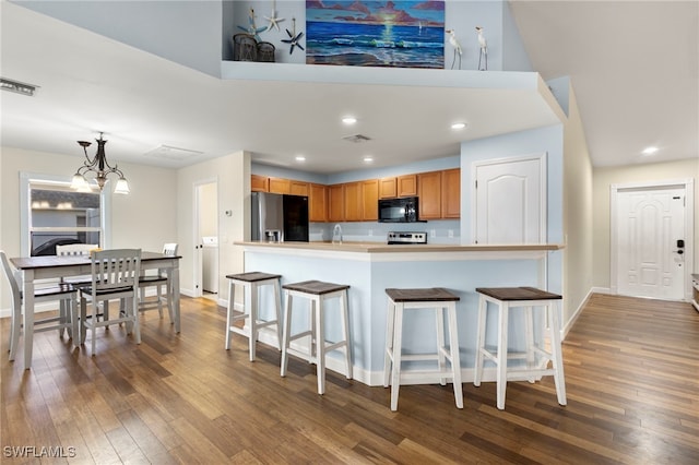 kitchen with decorative light fixtures, stainless steel refrigerator with ice dispenser, visible vents, light countertops, and black microwave