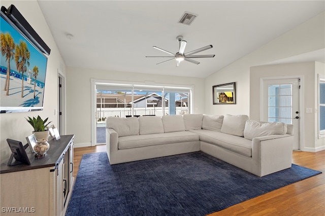 living area featuring baseboards, visible vents, ceiling fan, wood finished floors, and vaulted ceiling