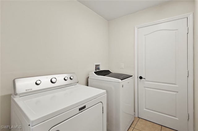 washroom with laundry area, washer and clothes dryer, and light tile patterned flooring