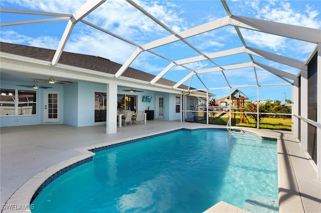 pool with a lanai, a patio area, a playground, and a ceiling fan