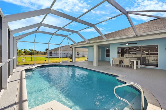 pool featuring glass enclosure, a ceiling fan, and a patio