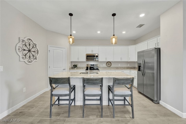 kitchen with white cabinets, light stone counters, sink, and stainless steel appliances