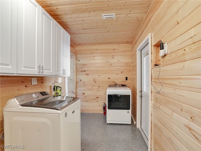 washroom with separate washer and dryer, cabinet space, wooden walls, and wood ceiling