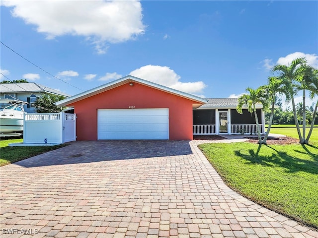 single story home featuring stucco siding, decorative driveway, fence, a front yard, and a garage