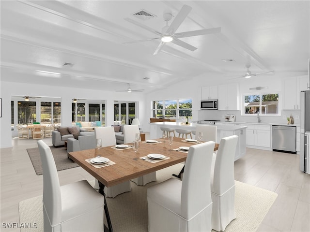 dining area with visible vents, ceiling fan, and vaulted ceiling with beams