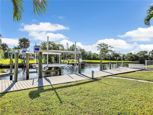 view of dock featuring a lawn, a water view, and boat lift