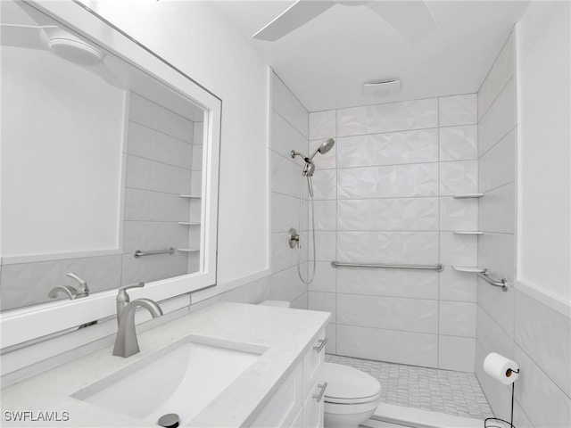 bathroom with vanity, toilet, and a tile shower