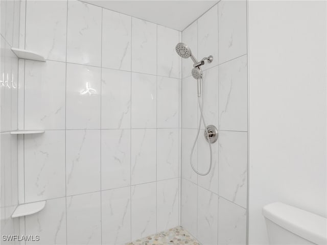 full bath with a tile shower and toilet