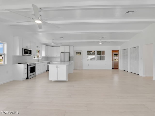 kitchen featuring a sink, appliances with stainless steel finishes, open floor plan, and a ceiling fan