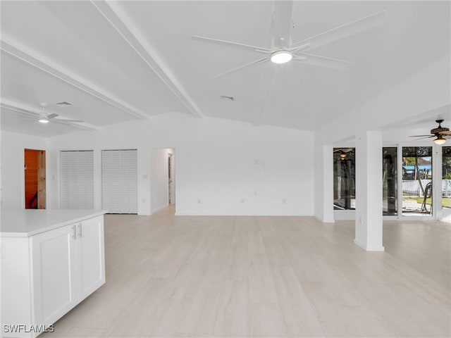 spare room with light wood finished floors, visible vents, baseboards, beam ceiling, and a ceiling fan