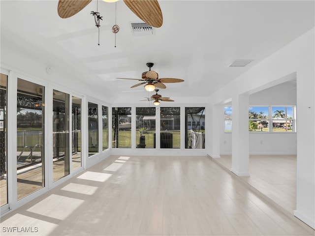 unfurnished sunroom with visible vents and ceiling fan