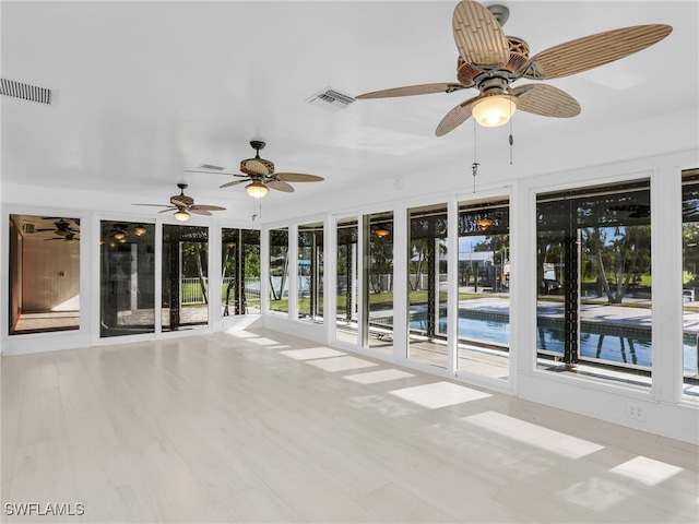 unfurnished sunroom featuring visible vents and ceiling fan