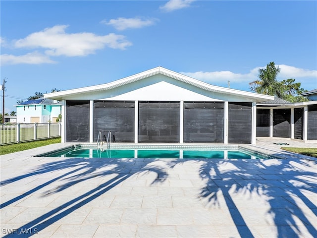 view of pool with a patio area, fence, a fenced in pool, and a sunroom