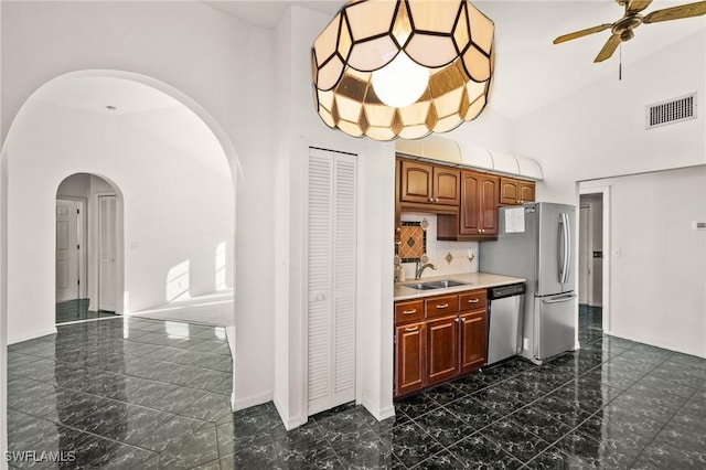 kitchen featuring ceiling fan, sink, stainless steel appliances, and high vaulted ceiling