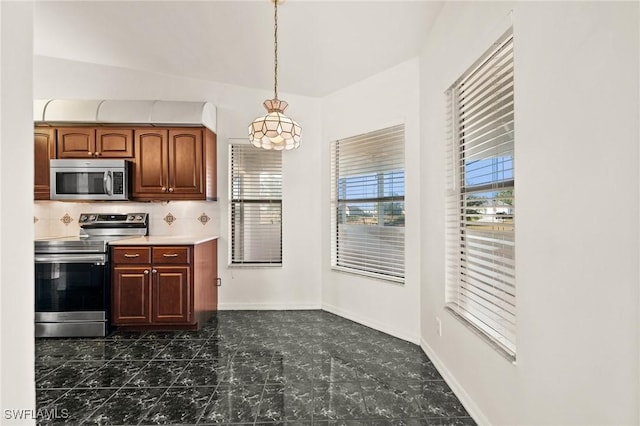 kitchen with backsplash, hanging light fixtures, stainless steel appliances, and lofted ceiling