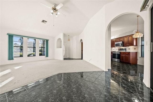 living room featuring ceiling fan, dark carpet, and vaulted ceiling