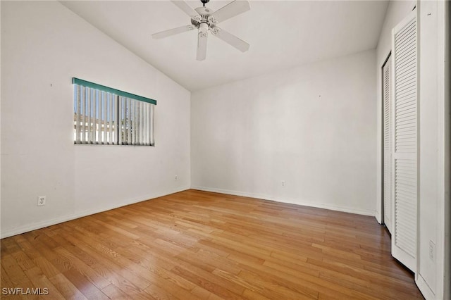 unfurnished bedroom featuring ceiling fan, a closet, vaulted ceiling, and light wood-type flooring