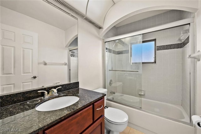 full bathroom with combined bath / shower with glass door, vanity, toilet, and tile patterned flooring