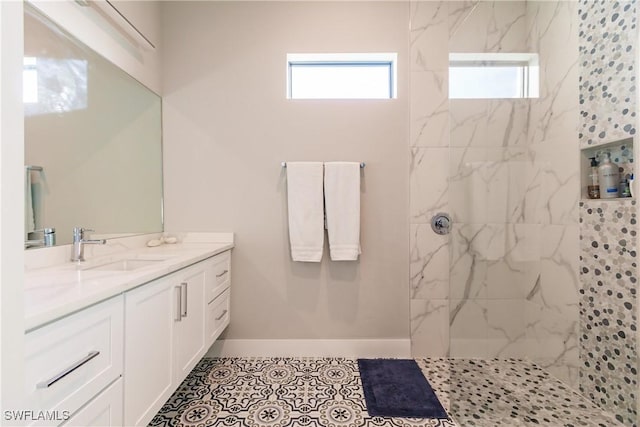 bathroom with tile patterned flooring, vanity, and tiled shower