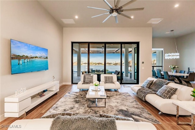 living room with a water view, light hardwood / wood-style flooring, and ceiling fan