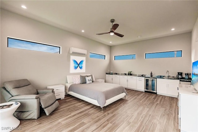 bedroom featuring light wood-type flooring, beverage cooler, ceiling fan, sink, and an AC wall unit