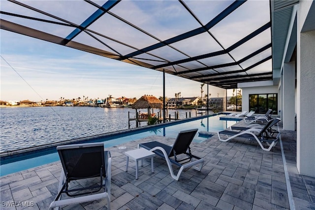 view of pool featuring a patio, a water view, and a lanai