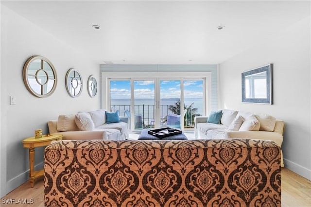 living room with a water view and light hardwood / wood-style flooring