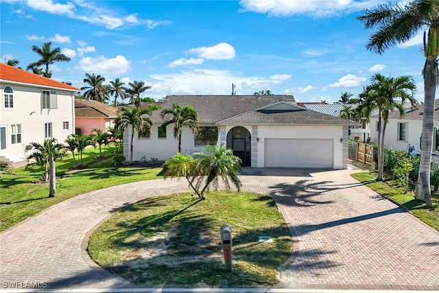 9940 Vanderbilt Dr, Naples, FL 34108 - view of front of property featuring an attached garage, stucco siding, fence, a front lawn, and decorative driveway