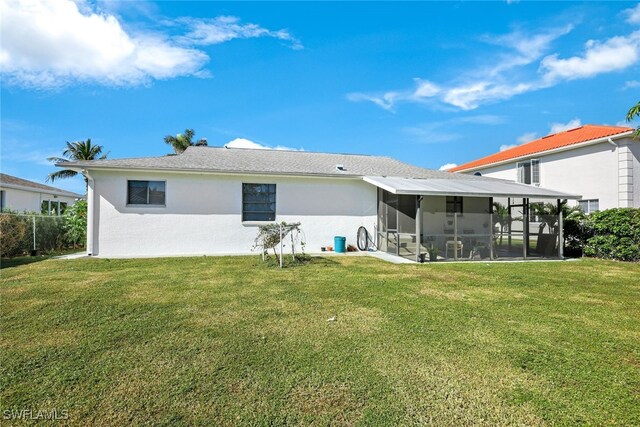 9940 Vanderbilt Dr, Naples, FL 34108 - back of house featuring a sunroom, stucco siding, and a lawn