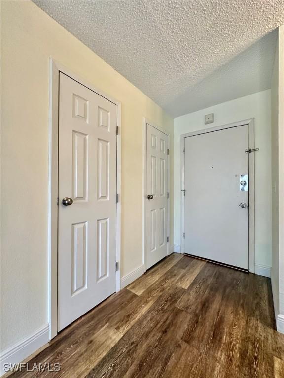 entrance foyer with a textured ceiling and dark wood-type flooring