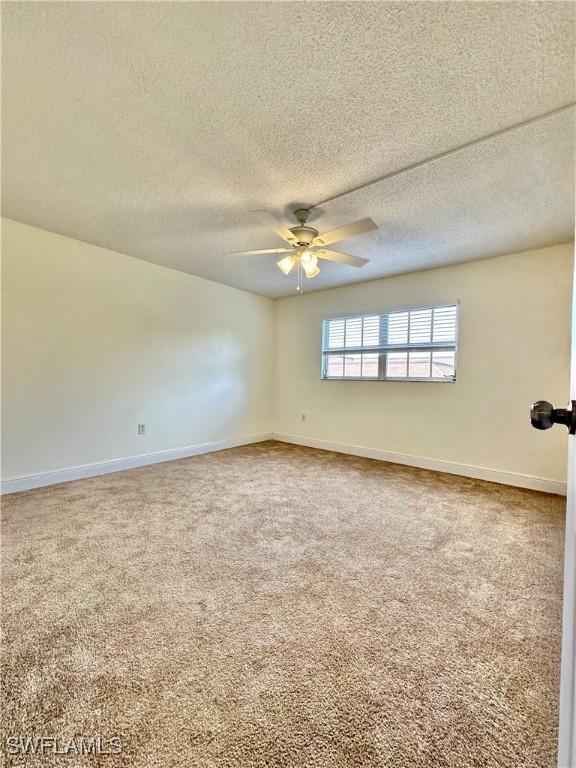 carpeted empty room with a textured ceiling and ceiling fan