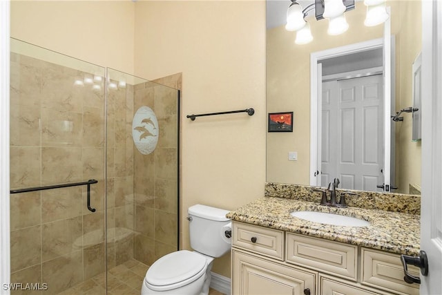 bathroom featuring vanity, toilet, and a shower with shower door