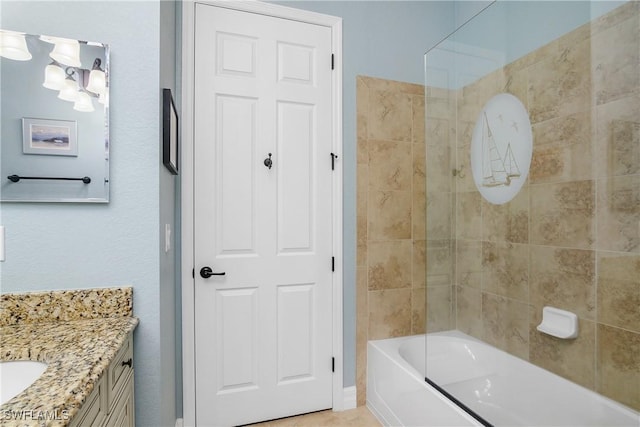 bathroom with tiled shower / bath and vanity