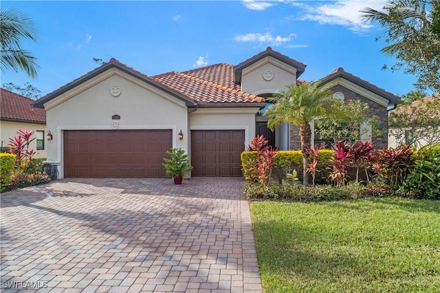 mediterranean / spanish-style house with a garage and a front lawn