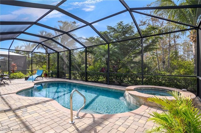 view of pool with glass enclosure, a patio area, and an in ground hot tub